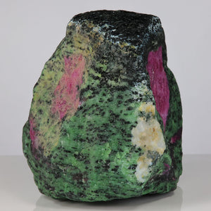 raw mineral specimen of green zoisite and violet red ruby