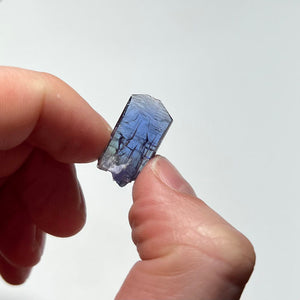 naturally colored tanzanite crystal in hand