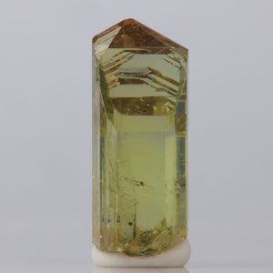 Clear Tanzanite crystal with yellow tint on a white background