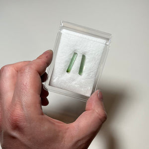 two natural tourmaline crystals with similar size and pale green tone
