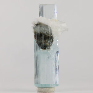 Reverse view of Pakistani aquamarine with fine vertical growth lines and white matrix attached near the center.