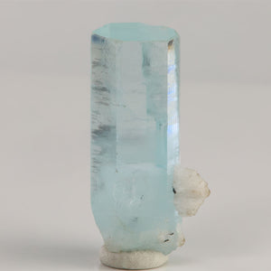 Side view of 8.37 gram Pakistani aquamarine showing subtle horizontal growth lines and reflective crystal faces.