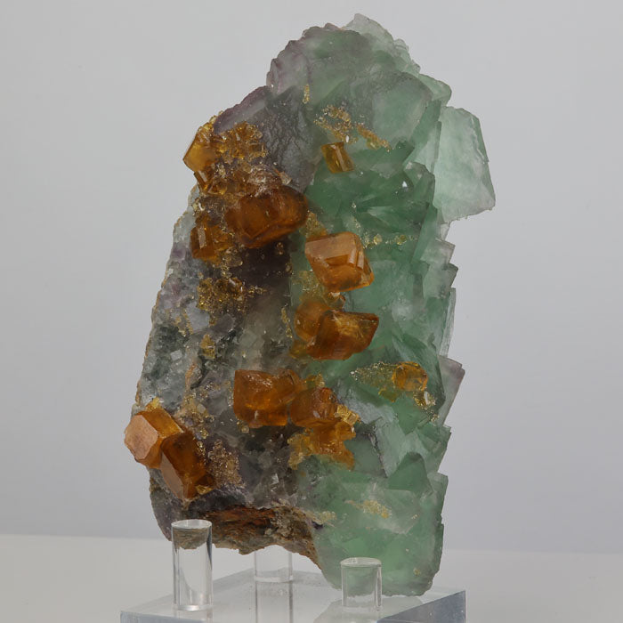 Orange barite mineral specimen on green fluorite