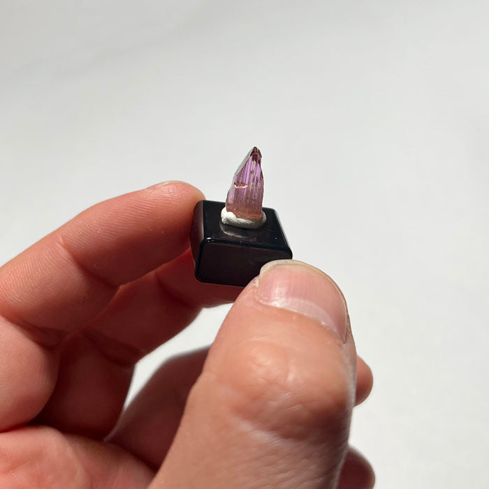 Tanzanite Crystal-like object with pink and purple hues on a white background