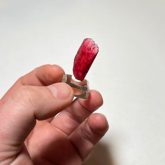 Deep pink rhodonite mineral specimen with dark inclusions