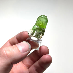 Bright green peridot crystal with matrix