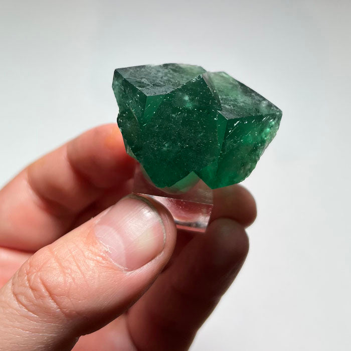 Front view of natural Rogerley fluorite from England showing overlapping cubic faces and rich emerald-green coloration.