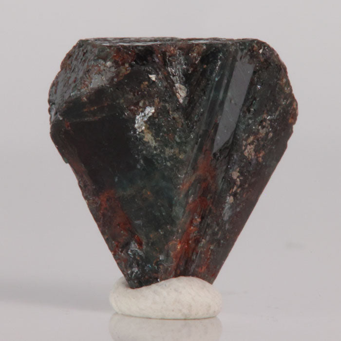 Alexandrite Mineral specimen on a white base with a gray background