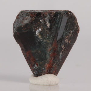 Alexandrite Mineral specimen on a white base with a gray background