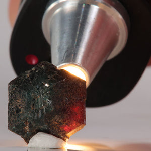Close-up of a Alexandrite under a magnifying glass with a blurred background