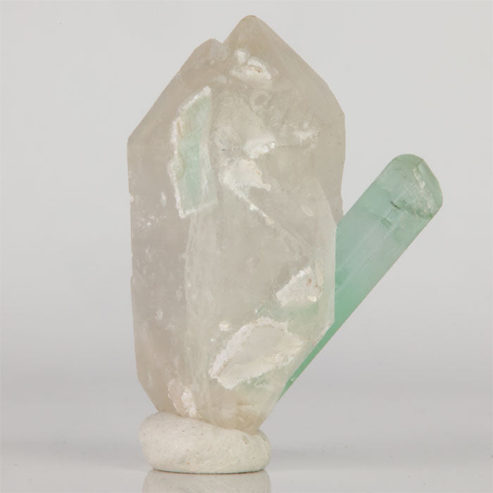 Side view of translucent double-terminated Quartz with an attached light green Tourmaline crystal.