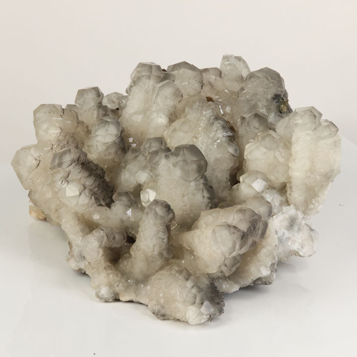 Clear calcite crystal cluster with gray zoning