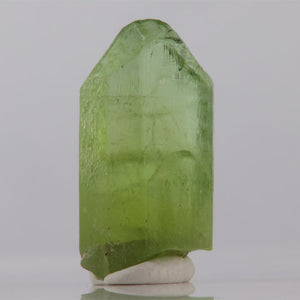 Green crystal on a white base with a gray background