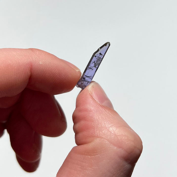 narrow tanzanite crystal in hand