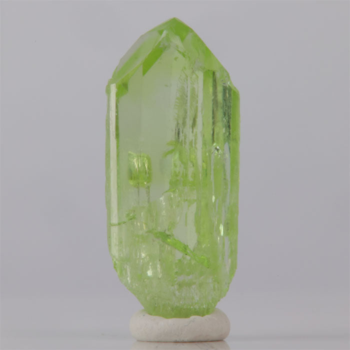 Green crystal on a white base against a gray background