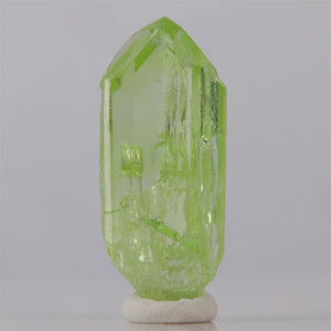 Green crystal on a white base against a gray background