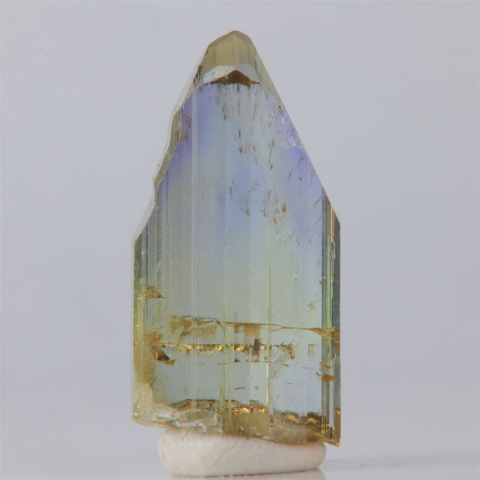 Tanzanite Crystal with multicolored facets on a white background