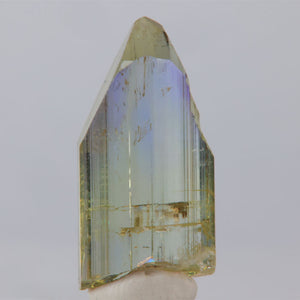 Tanzanite Crystal prism with multicolored facets on a white background