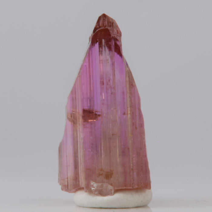 Tanzanite Crystal-like object with pink and purple hues on a white background