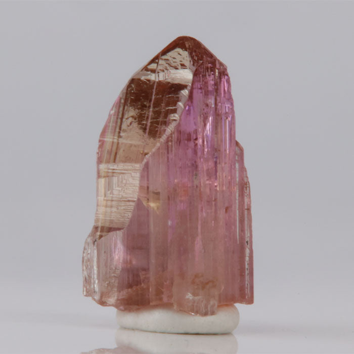 Tanzanite Crystal with pink and brown hues on a white background