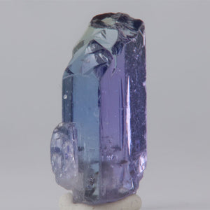 Purple tanzanite crystal on a white background