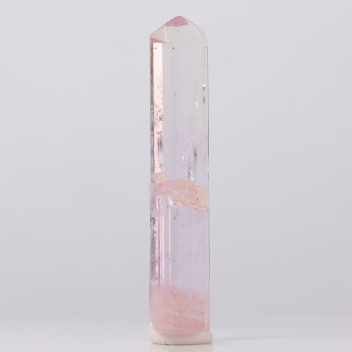 Natural Pink Topaz Crystal tower with pink and white coloration on a light gray background