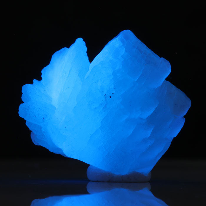 Blue prehnite specimen glowing electric blue under UV light