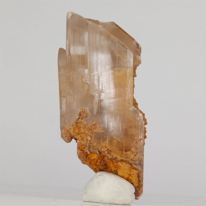 translucent gypsum crystal specimen with earthy matrix