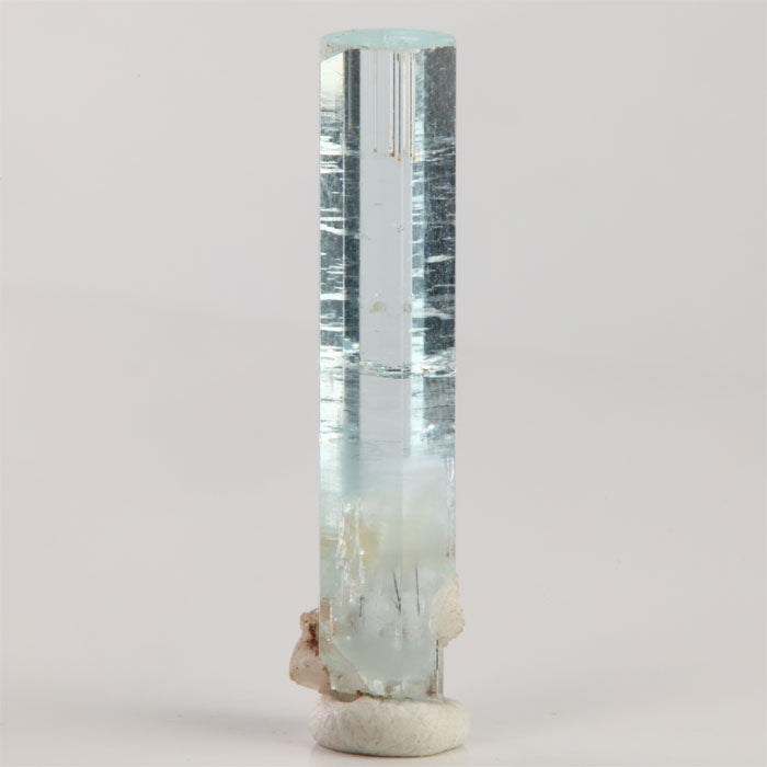Front view of 3.54 gram aquamarine showing a distinct horizontal growth line and attached white mineral matrix near the base.