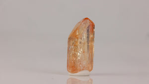 Brazilian topaz specimen with warm orange hues and natural termination