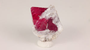 bright red spinel crystal on white matrix