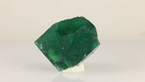 Front view of natural Rogerley fluorite from England showing overlapping cubic faces and rich emerald-green coloration.