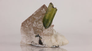 Reverse view of Afghan tourmaline and quartz cluster showing the green crystal, textured quartz faces, and white mineral matrix.