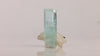 Side view of Pakistani aquamarine revealing internal growth patterns, scattered dark inclusions, and reflective crystal faces.