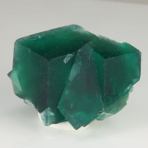 Front view of Rogerley Mine fluorite showing two broad emerald-green cubic crystals with a prominent overlapping crystal.