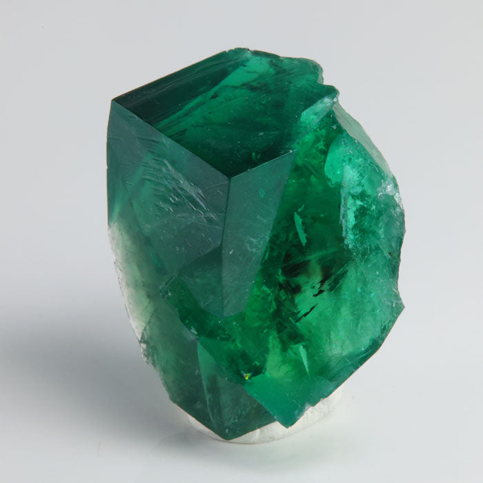 Deep emerald-green Rogerley Mine fluorite twin crystals displaying sharp cubic faces and gemmy translucency.