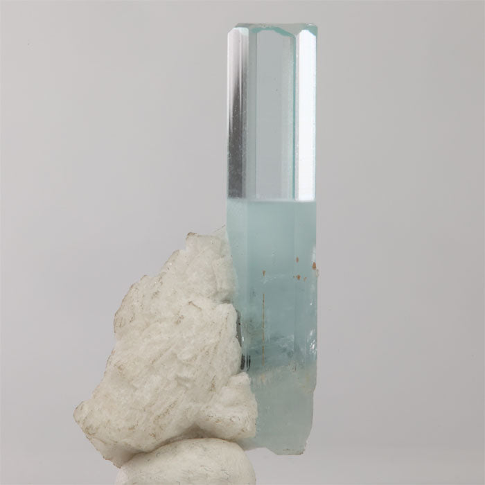 Pale blue aquamarine crystal on white matrix from Shigar Mine Pakistan with a black mineral inclusion.