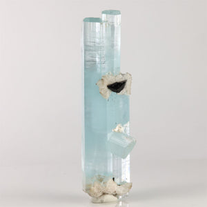 Tall aquamarine crystal cluster from Shigar Mine Pakistan with two parallel blue crystals and attached white matrix.