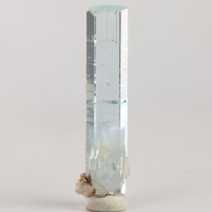 Reverse angle of natural Pakistani aquamarine displaying a narrow hexagonal shape and exceptional transparency along its length.