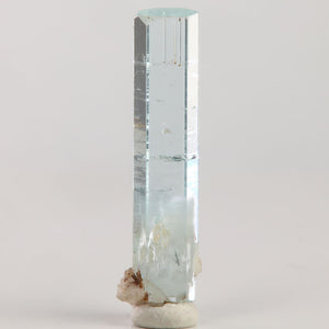 Reverse angle of natural Pakistani aquamarine displaying a narrow hexagonal shape and exceptional transparency along its length.